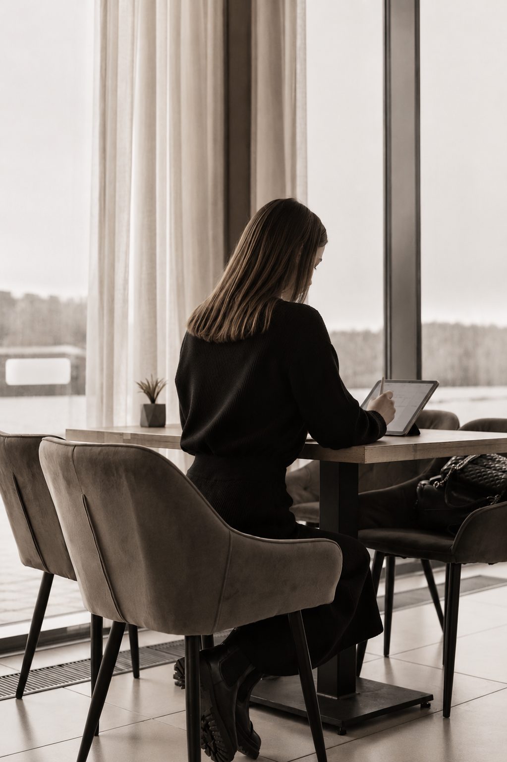 A professional working calmly at a desk beside a large window